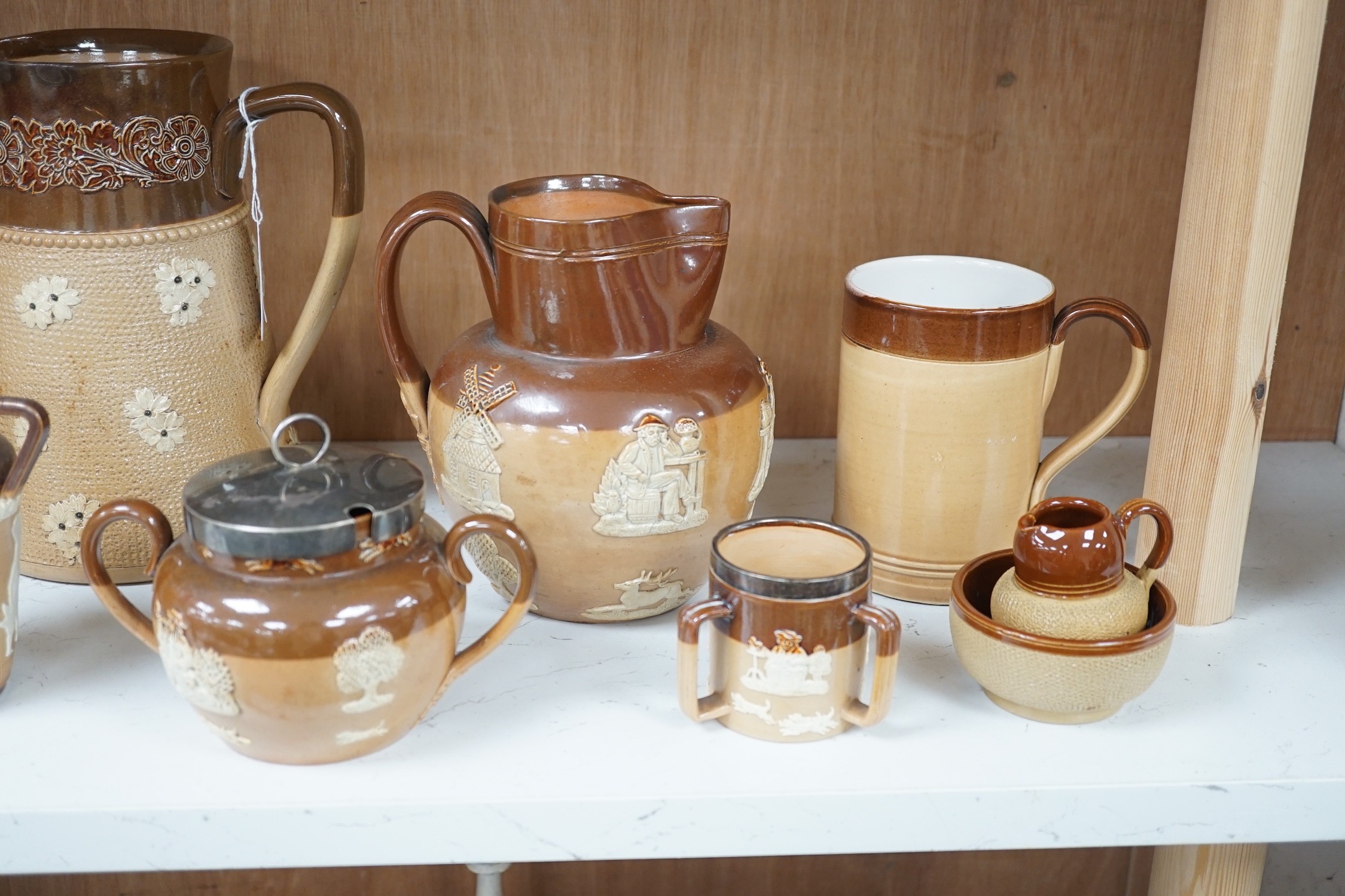 A group of Doulton stoneware jugs, storage jar, beakers, bowls etc